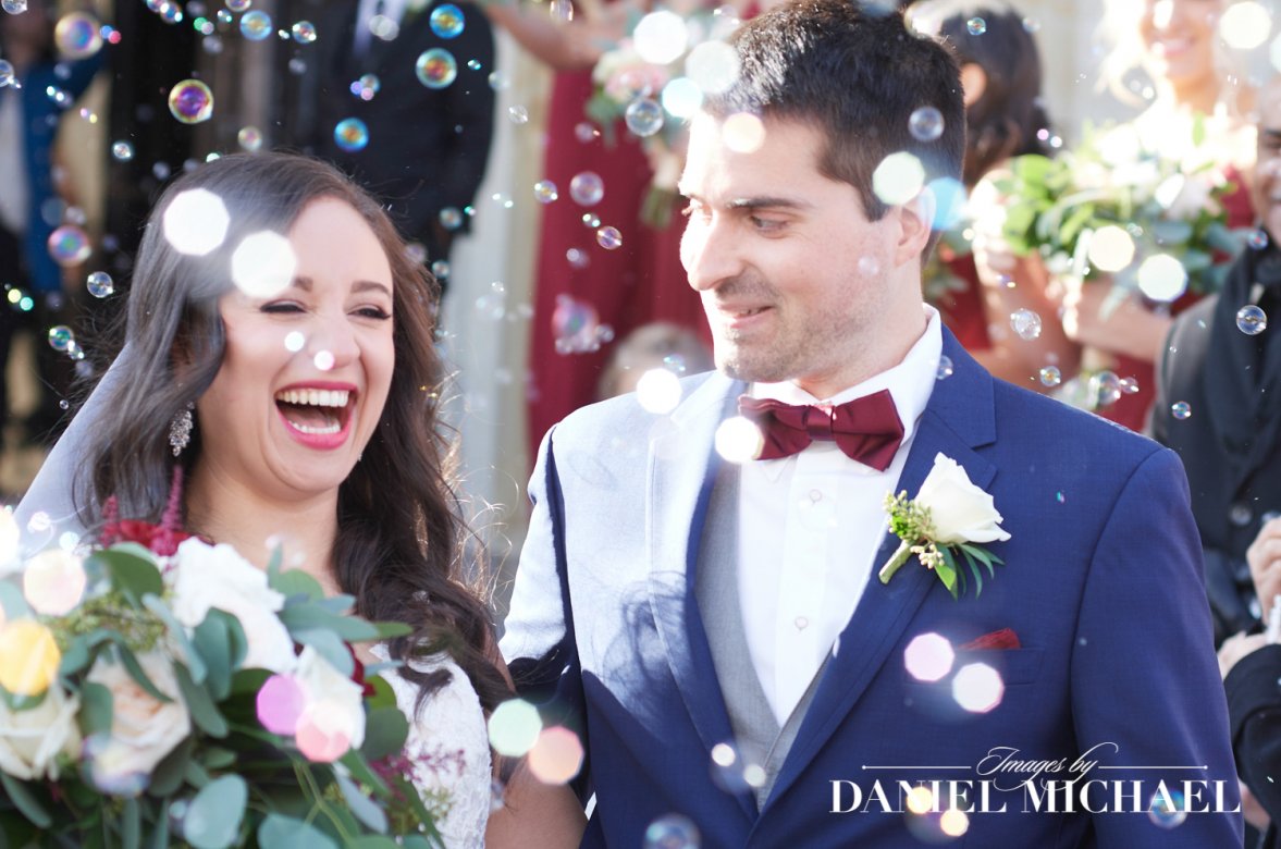 Candid Photo of Happy couple laughing during a bubble exit at their wedding in Cincinnati, captured by a wedding photographer